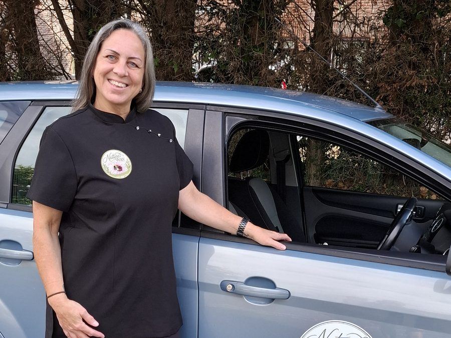 Pauline Capon in uniform standing beside the Nature's Way Mobile Massage car