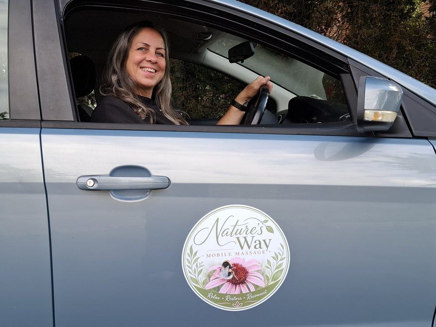 The Nature's Way Mobile Massage logo on the car door, with Pauline in the driver's seat